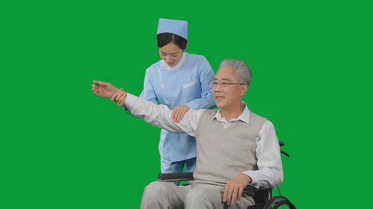 4K绿幕女护士给老年病人捏肩按摩手臂视频的预览图