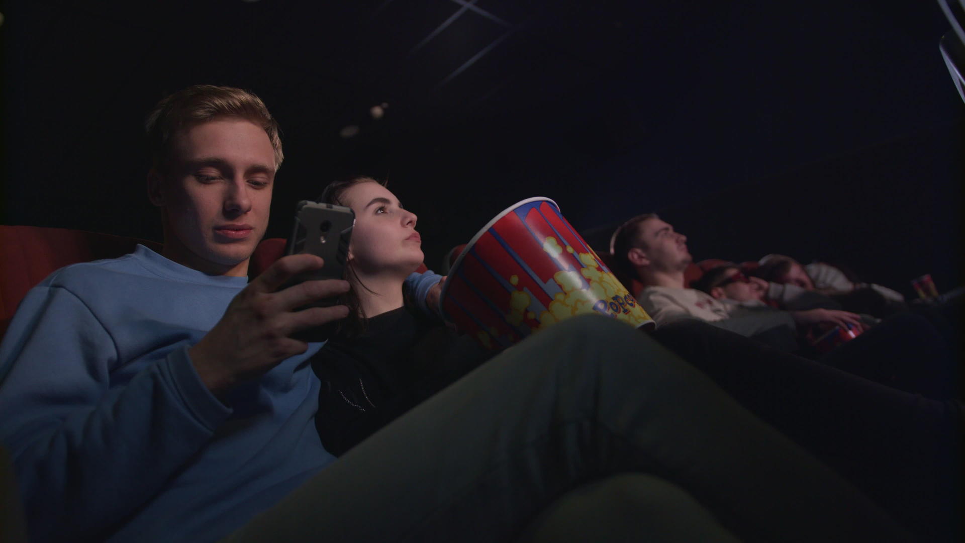 年轻人在电影院使用智能手机视频的预览图