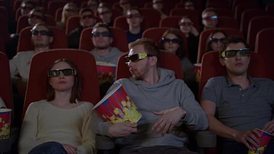 坐在电影院看3D年轻人吃爆米花视频的预览图