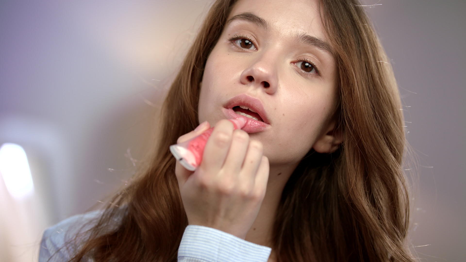 年轻女性在嘴唇上涂口红视频的预览图