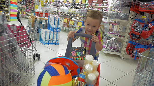 商场里一个快乐的男孩推着一辆车视频的预览图