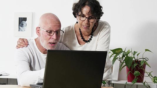 家中使用笔记本电脑电脑的老年夫妇视频的预览图