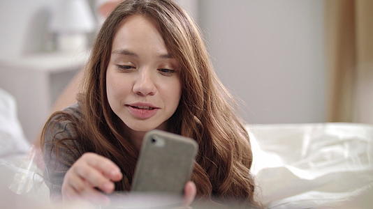 在床上用手机自拍的年轻女子视频的预览图
