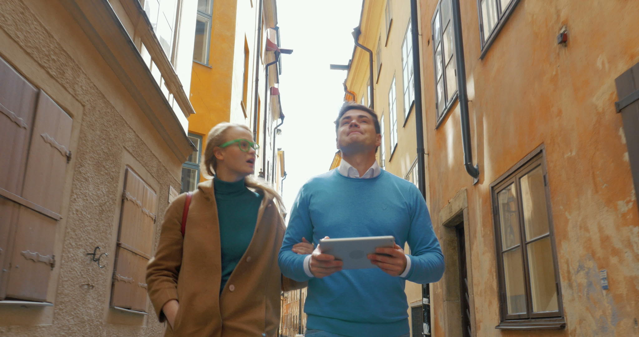 年轻夫妇走在旧的狭窄街道上视频的预览图