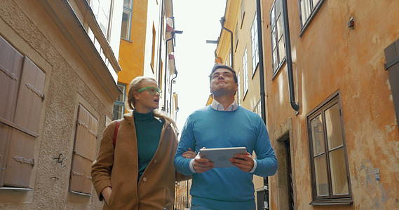 年轻夫妇走在旧的狭窄街道上视频的预览图