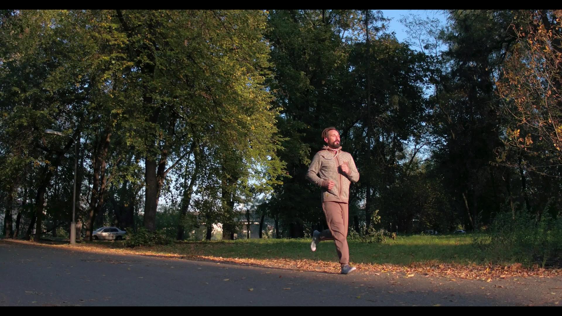 男人在绿秋林中奔跑视频的预览图