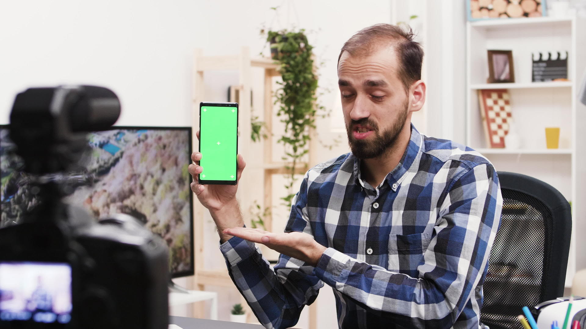 带有绿色屏幕的有吸引力的影响器记录电话审查视频的预览图
