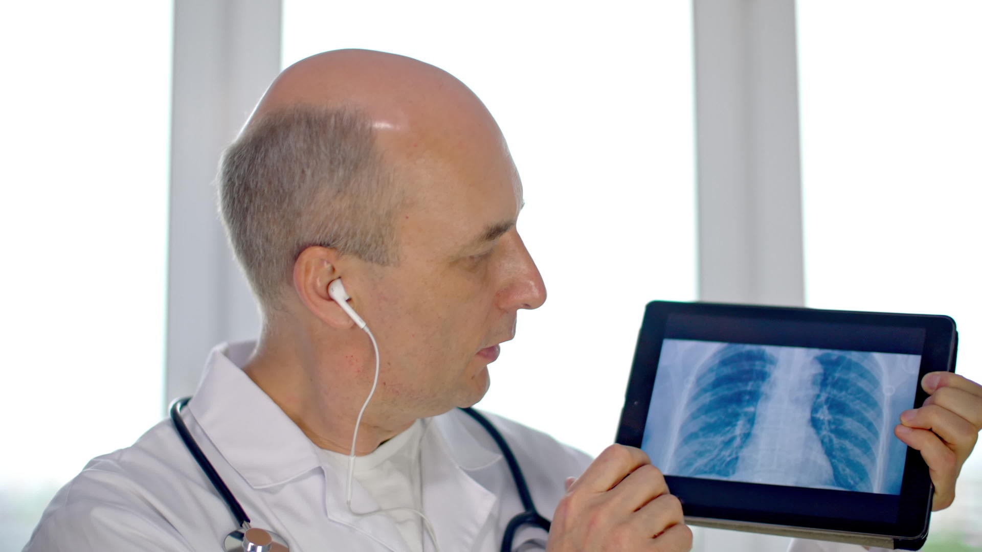执业医生在平板电脑上电脑上显示肺部扫描肺科医生在远程接收时显示肺炎X射线照片视频的预览图