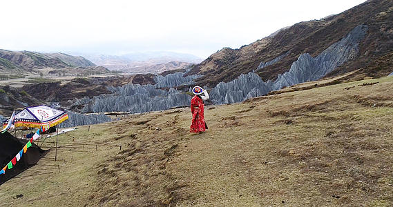 甘孜藏族自治州墨石公园藏族女孩背影航拍4K视频的预览图