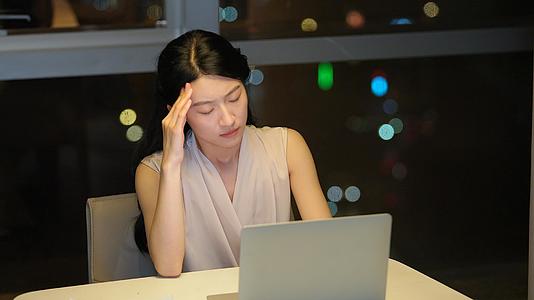 妇女熬夜加班头痛视频的预览图