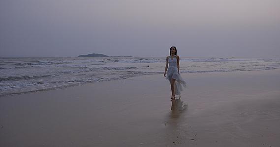 8K傍晚海边沙滩上的年轻女性视频的预览图
