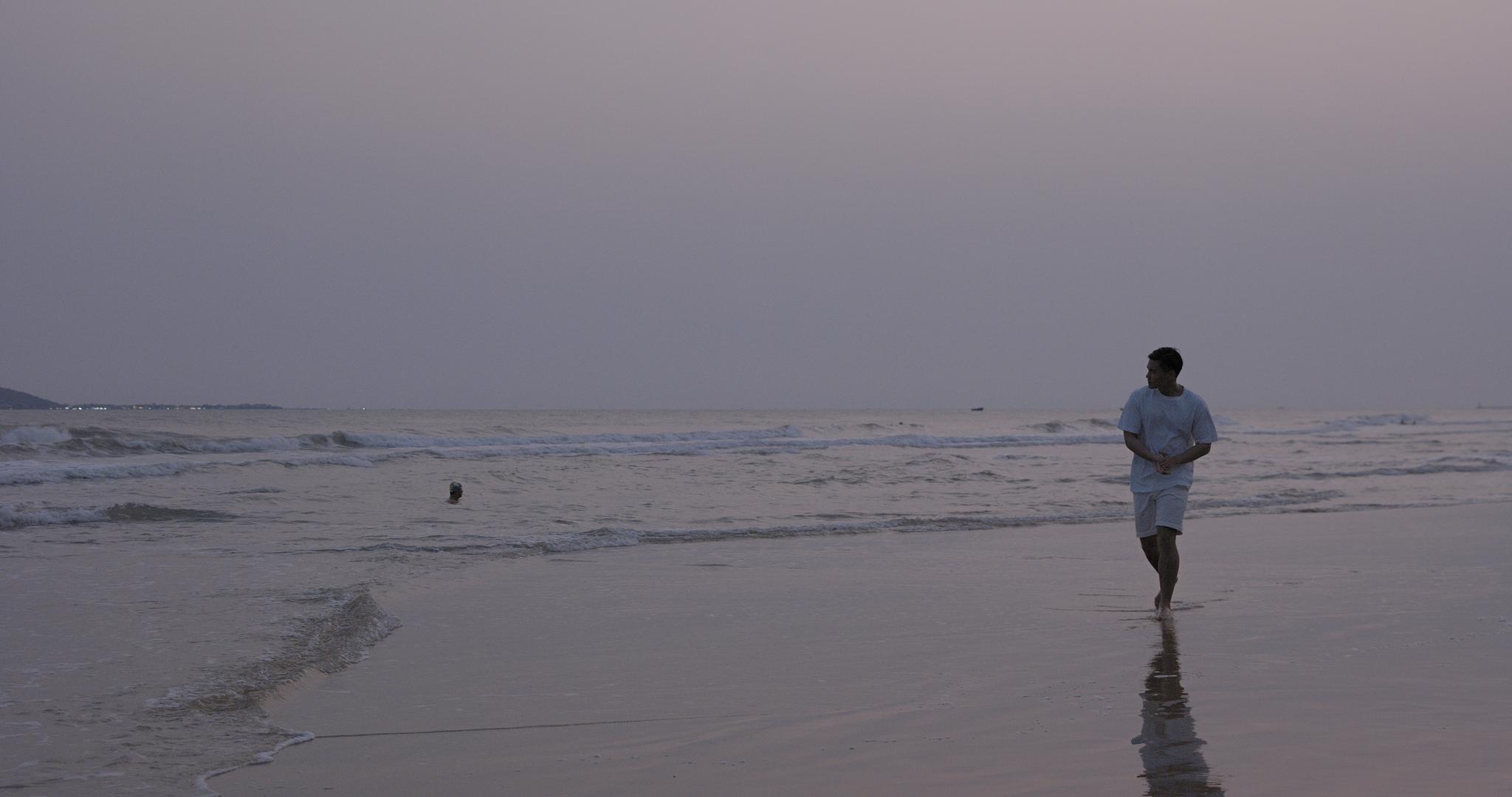 8K傍晚海边沙滩上漫步的男青年视频的预览图