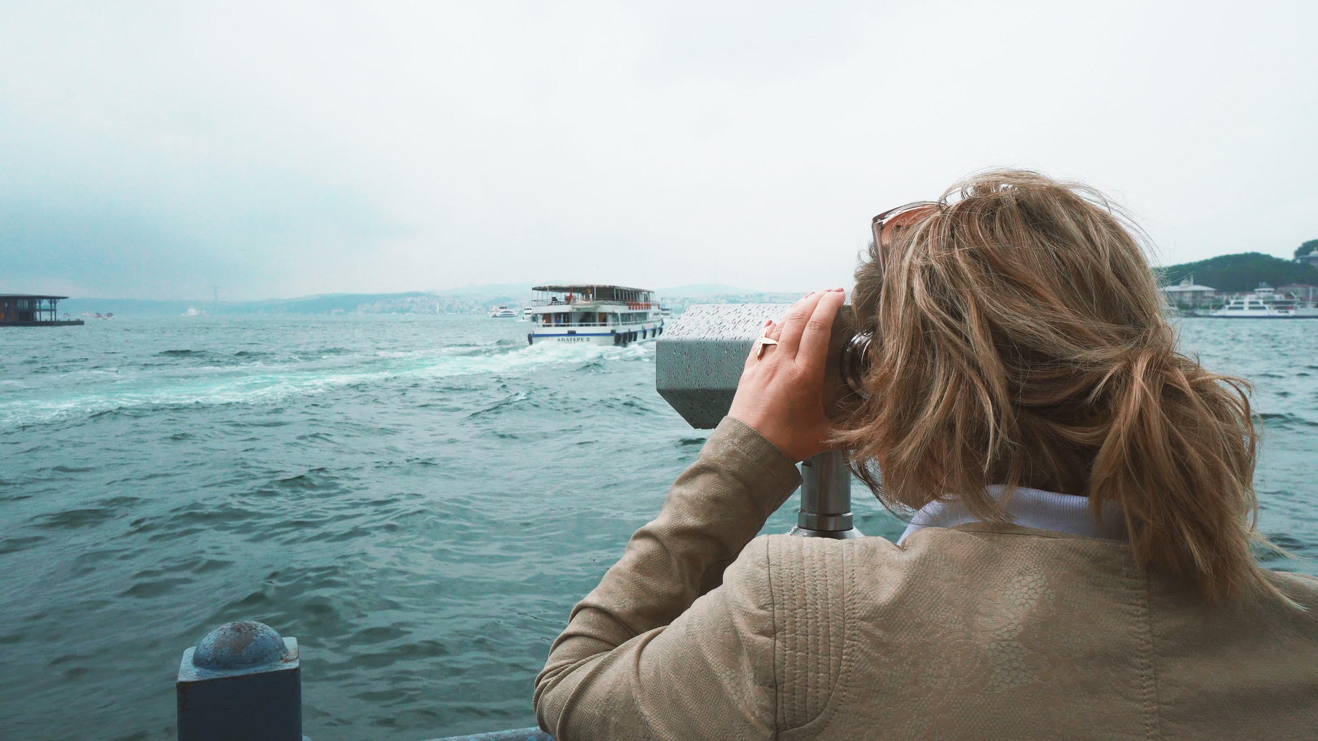 金发女郎用双筒望远镜观察船视频的预览图