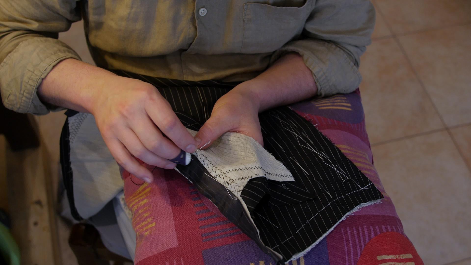 时装设计师用手垫缝制两层或两层以上的织物使一层更坚固视频的预览图