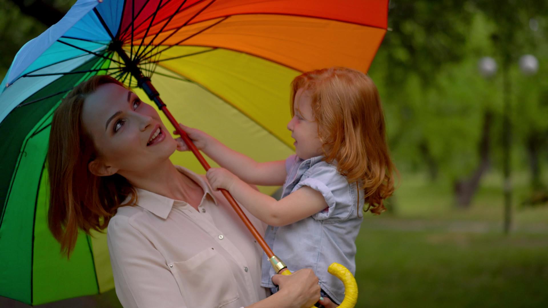 快乐的母亲和孩子在彩虹伞下视频的预览图