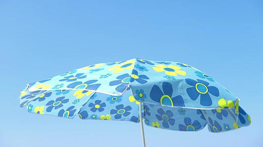 雨伞在沙滩上轻微漂浮视频的预览图