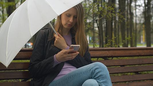 一个带伞的重女人坐在凳子上视频的预览图