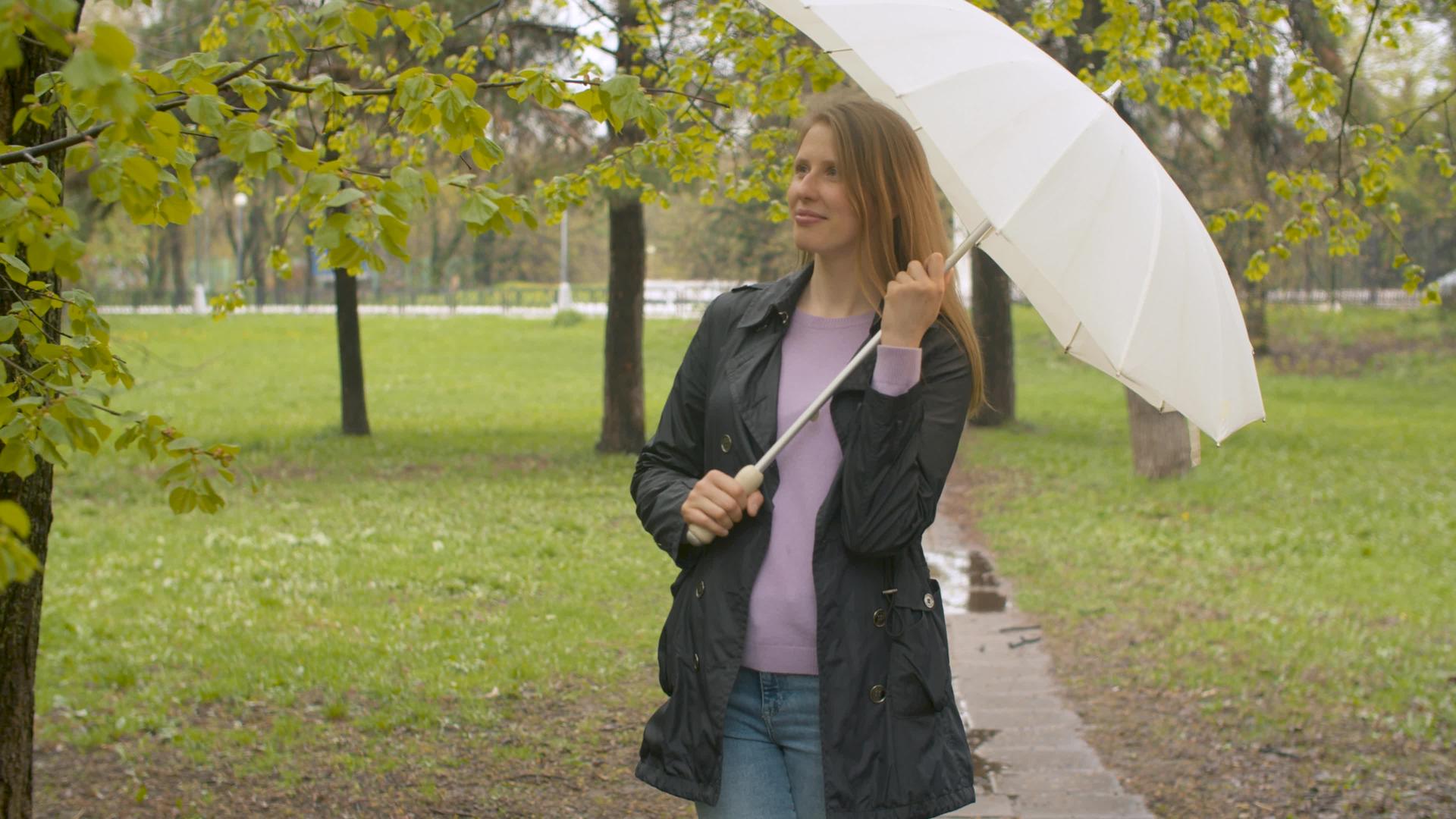 公园里有带伞的快乐女人视频的预览图