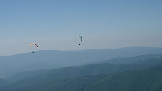 在阳光明媚的蓝天上玩滑翔伞视频的预览图