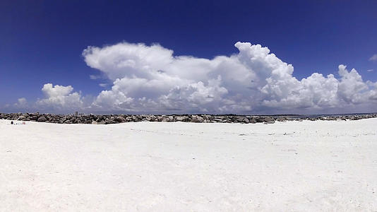 白沙滩边上的白云翻腾延时摄影视频的预览图