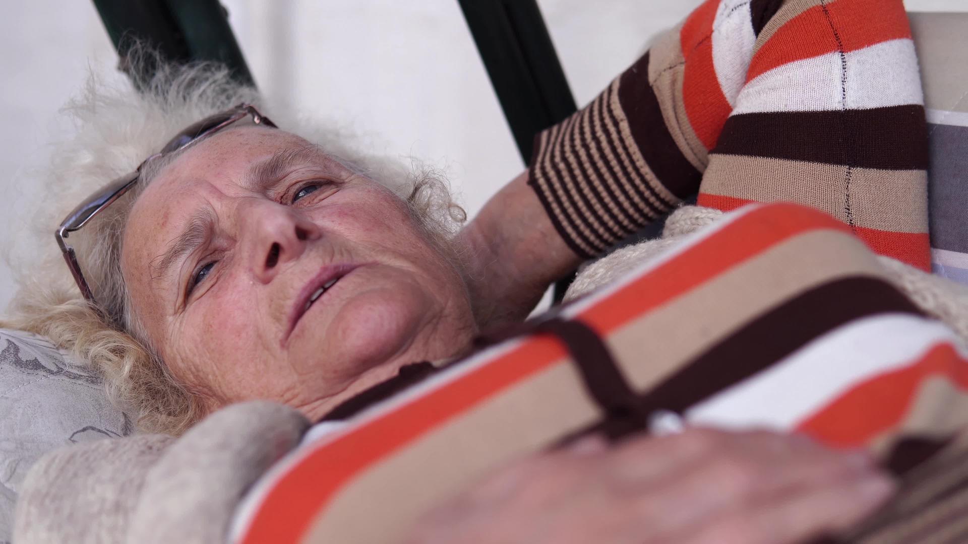 睡在花园门廊的摇摆床上年长的女人和女人睡在一起视频的预览图