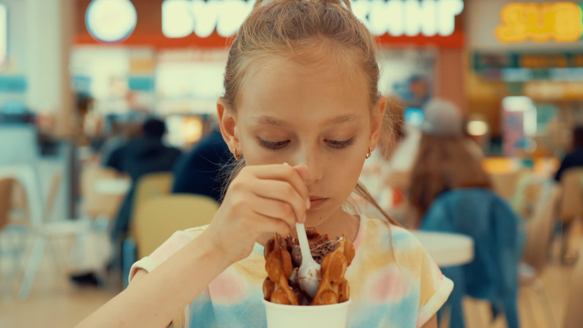 年轻女孩在购物中心吃冰淇淋甜点和华夫饼干视频的预览图
