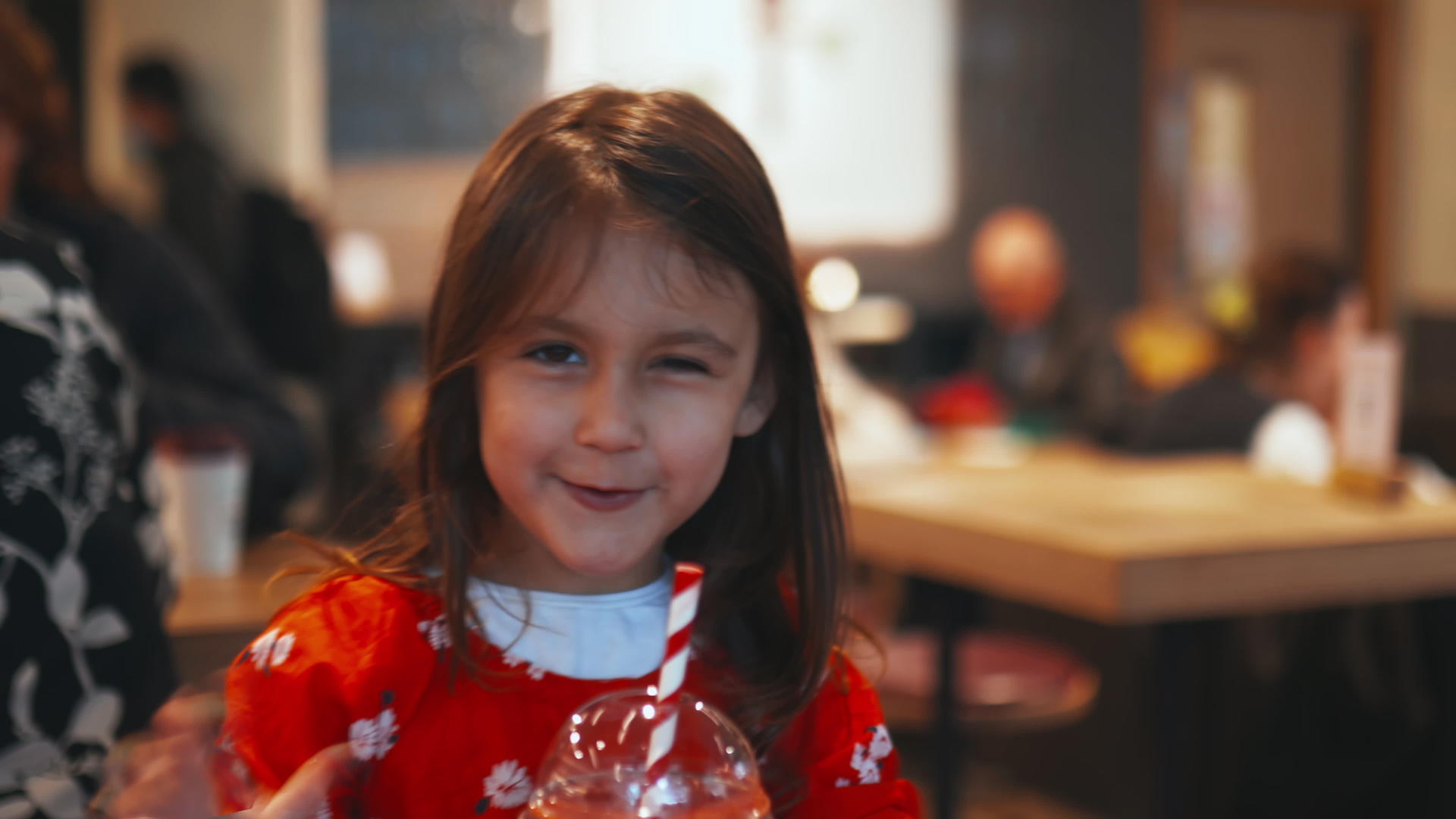 小黑发女孩坐在桌子上喝着红冰沙视频的预览图