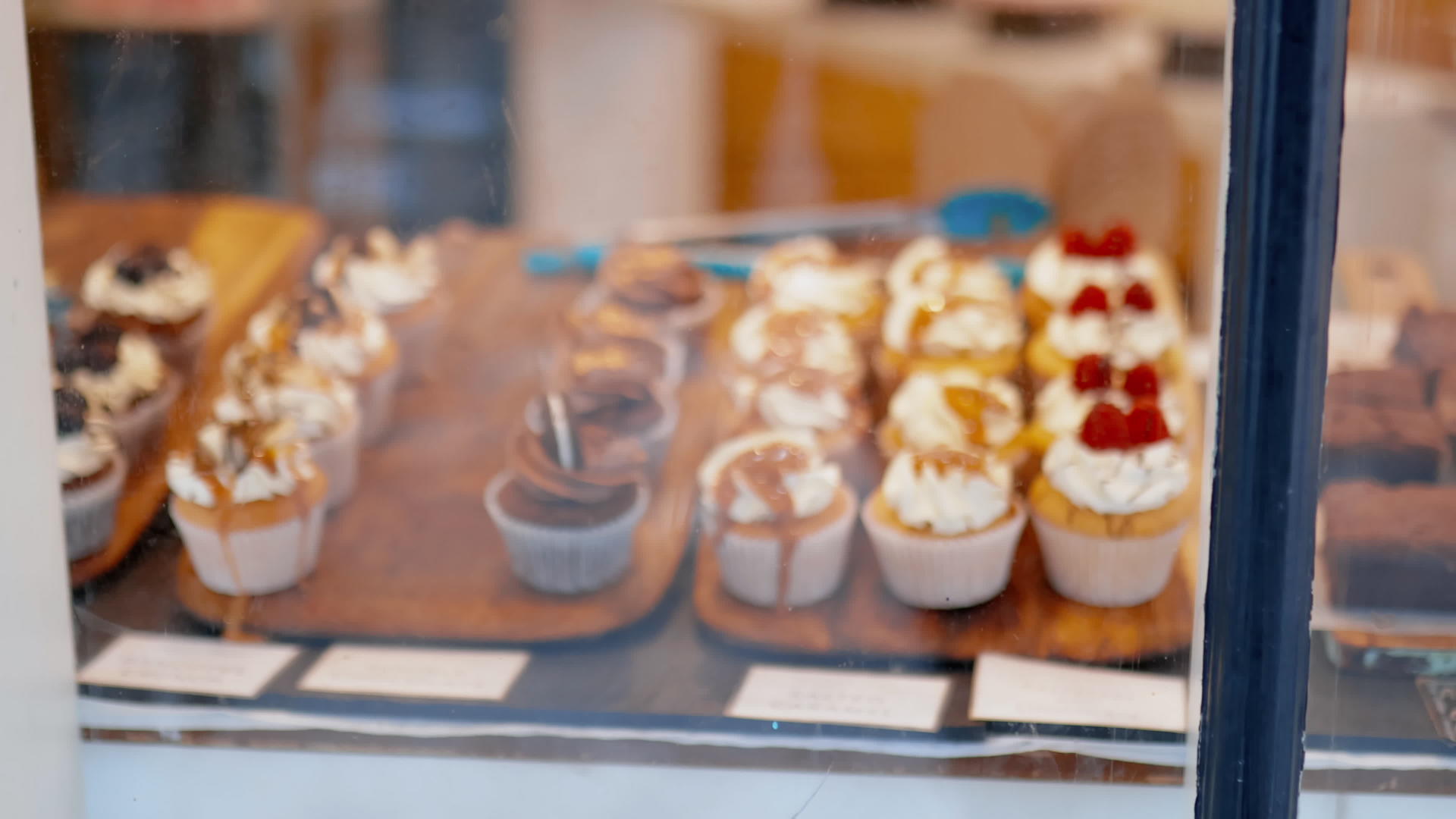 通过面包店的窗户彩色巧克力和草莓纸杯蛋糕视频的预览图