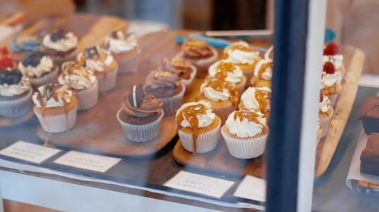彩色巧克力和草莓纸杯蛋糕通过面包店的窗户视频的预览图