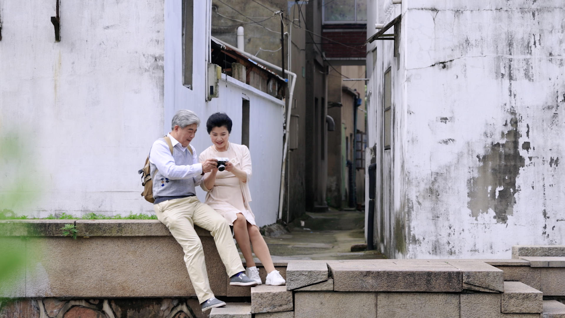 老年夫妇在古巷前坐着拍照片聊天视频的预览图
