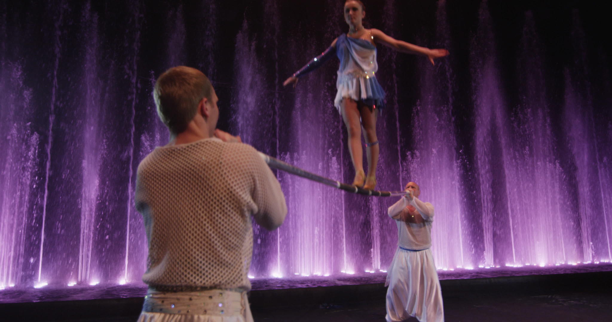 一群杂耍演员用电杆对抗彩色喷泉视频的预览图