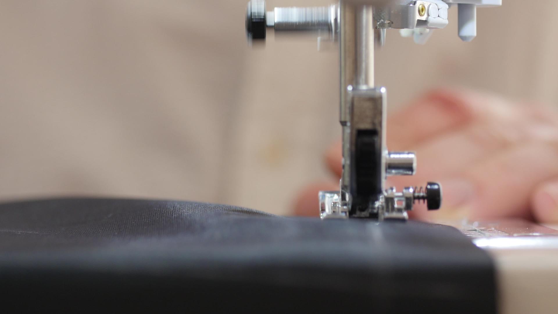 男人用手推材料在缝纫机上近距离拍摄视频的预览图