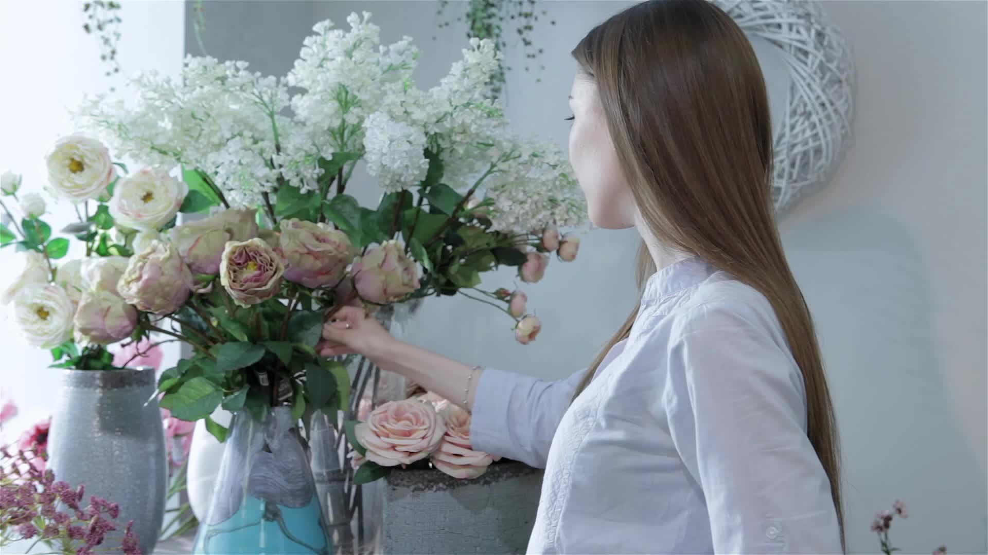 女花商在花店的花瓶里安排花视频的预览图