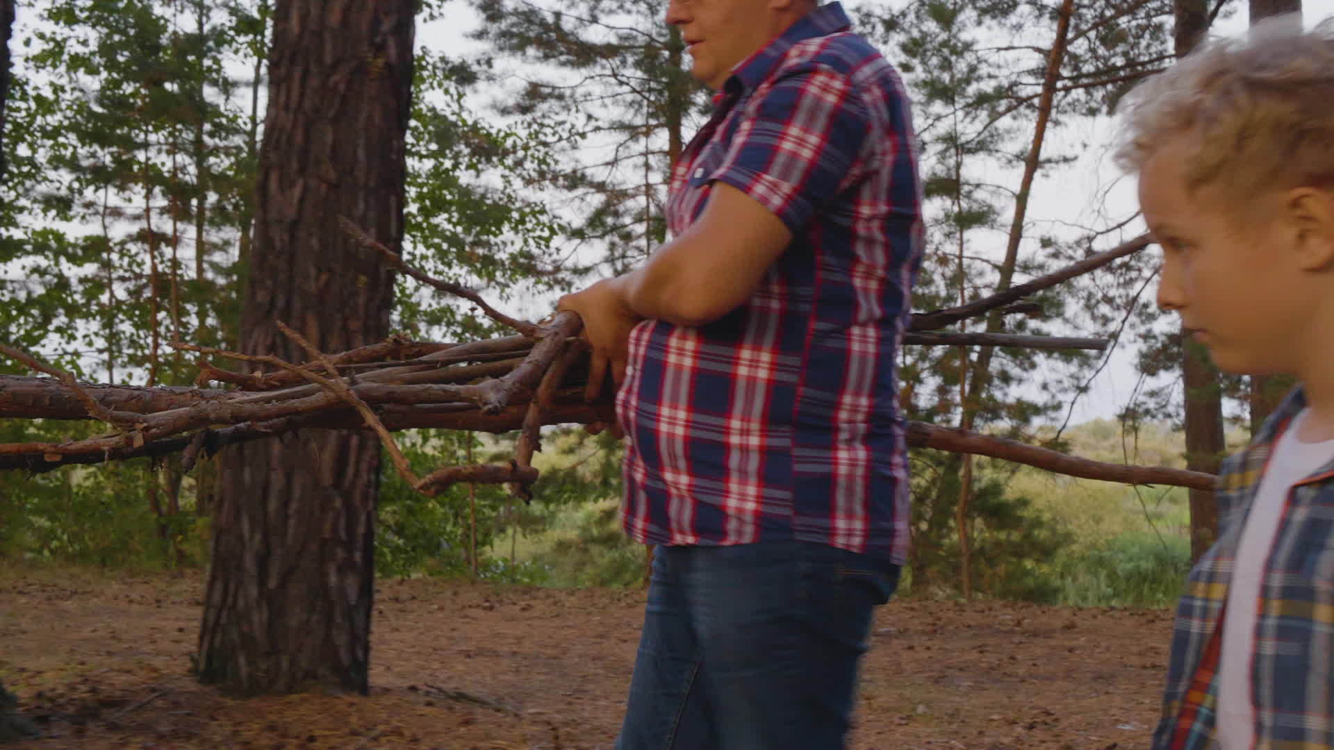 儿子和父亲在森林里用木柴伐木视频的预览图