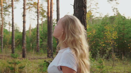 美丽的女孩在松林中行走视频的预览图