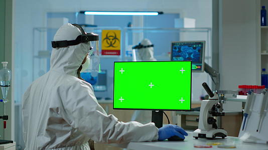 穿着保护服的科学家在电脑上打绿色模型字符视频的预览图