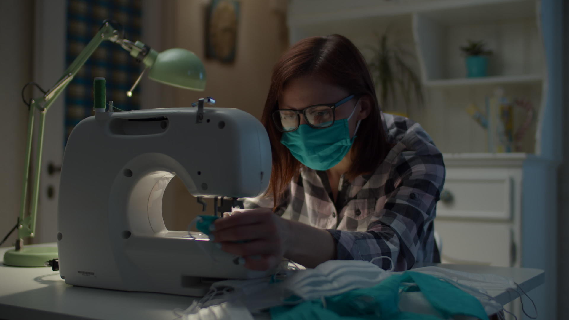 戴口罩的女性在缝纫机上缝制口罩视频的预览图