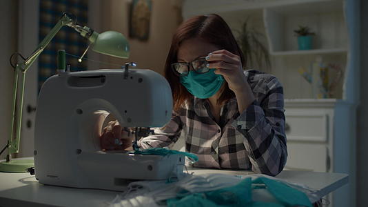 在家工作的缝纫机上作的缝纫机上缝制防护口罩视频的预览图