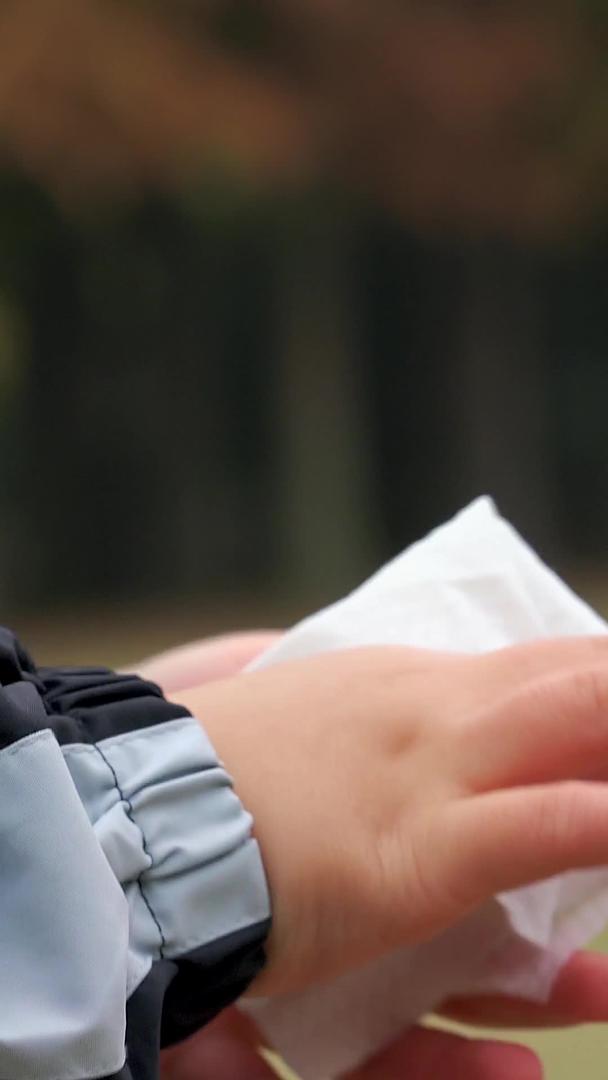 秋冬公园小男孩手部消毒后用纸巾擦拭特写视频的预览图