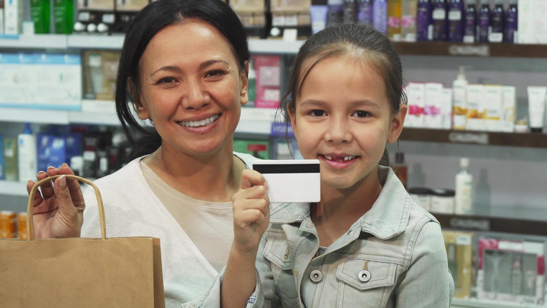 母亲和女儿用信用卡在药店购物视频的预览图