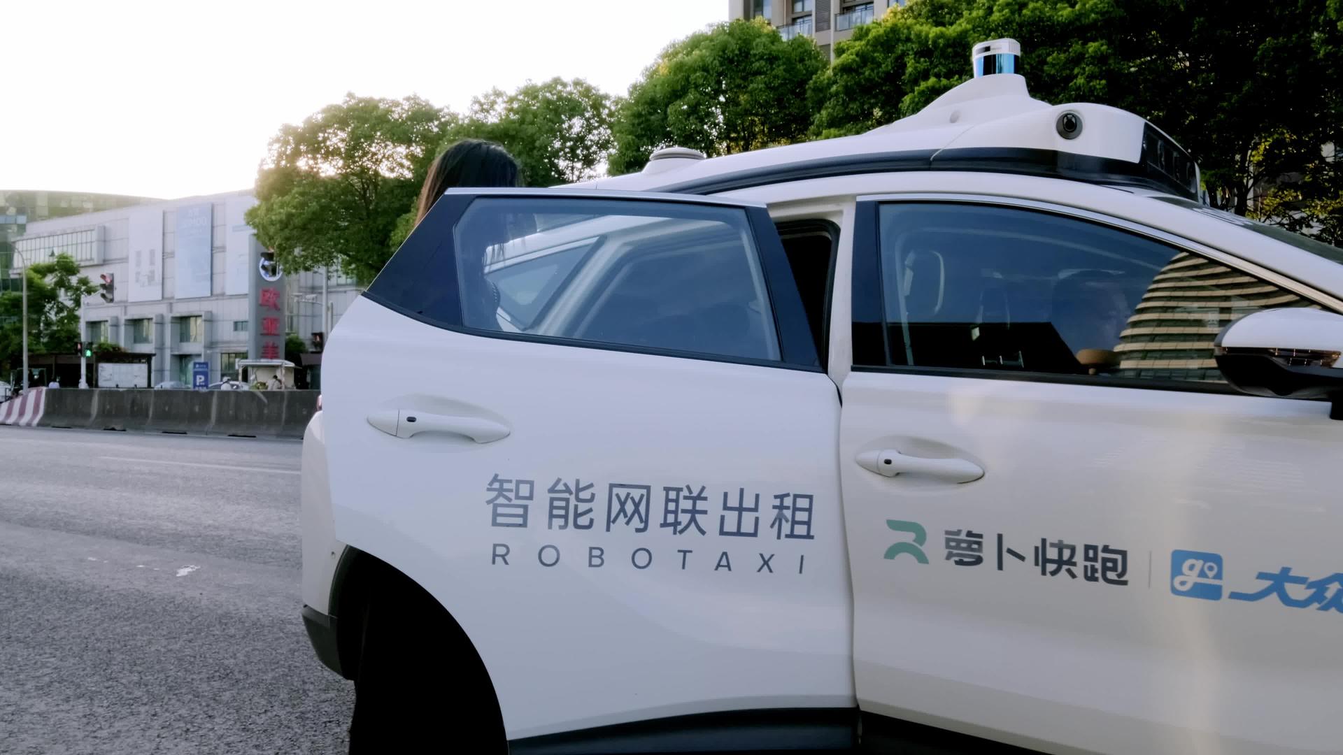 年轻女性在街上乘坐萝卜快跑无人驾驶汽车视频的预览图