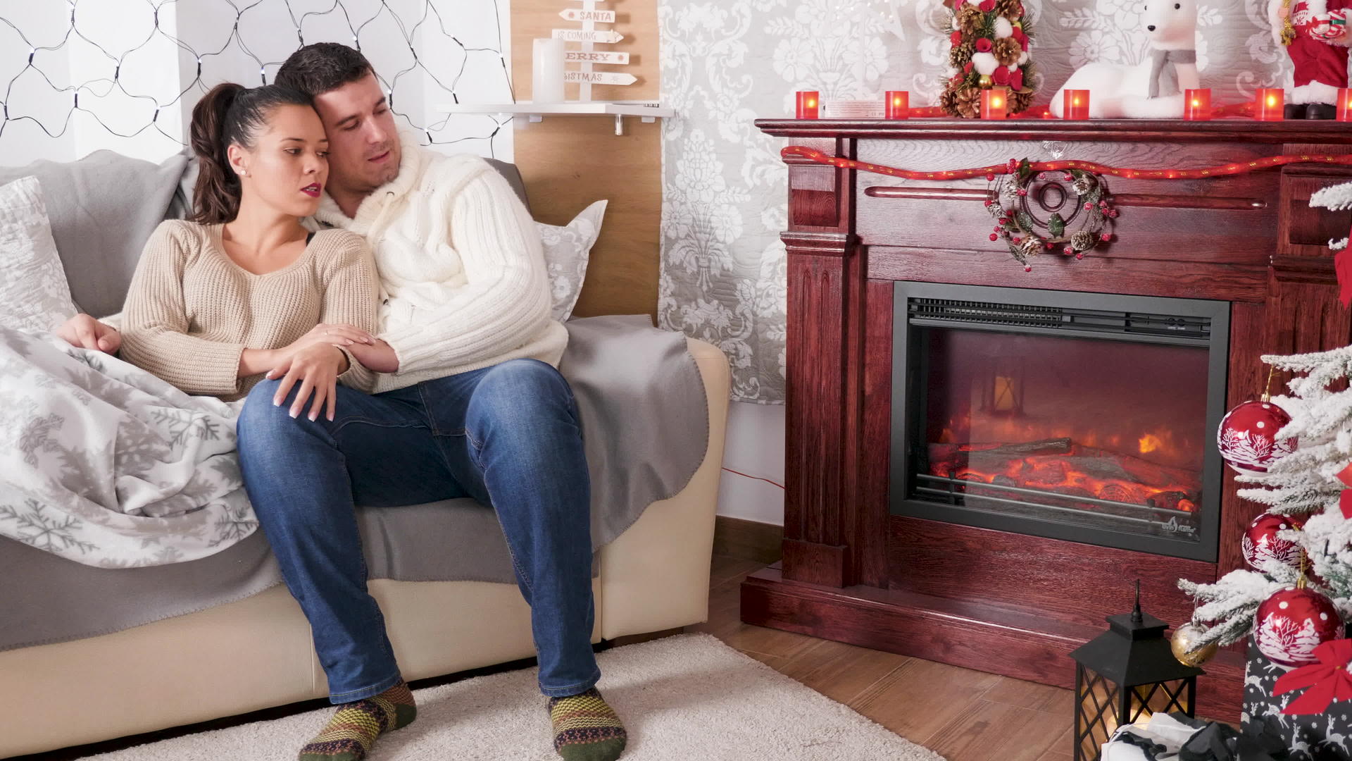 一对漂亮的夫妇躺在床上看着圣诞装饰室的壁炉视频的预览图