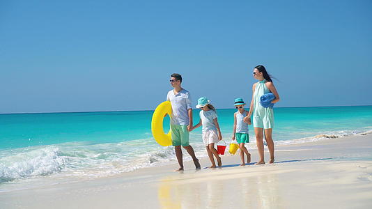 在热带沙滩度假期间四个人有一个幸福美好的家庭视频的预览图