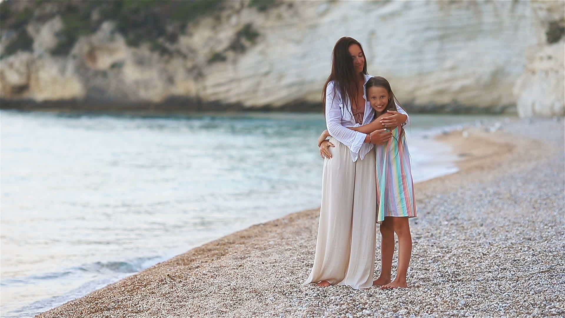 美丽的母亲和女儿在海滩上视频的预览图