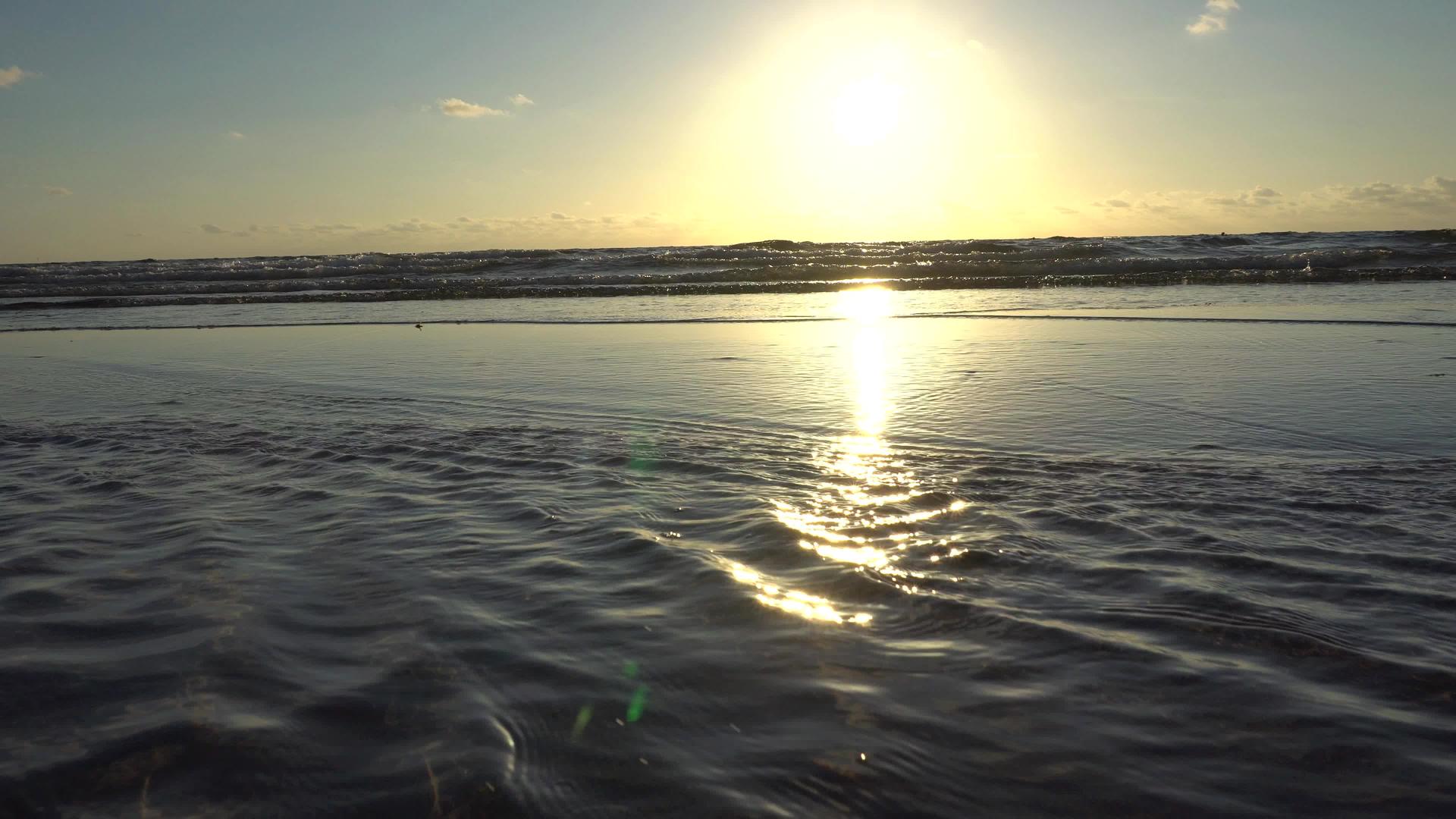 海滩上的阳光照在水面上视频的预览图