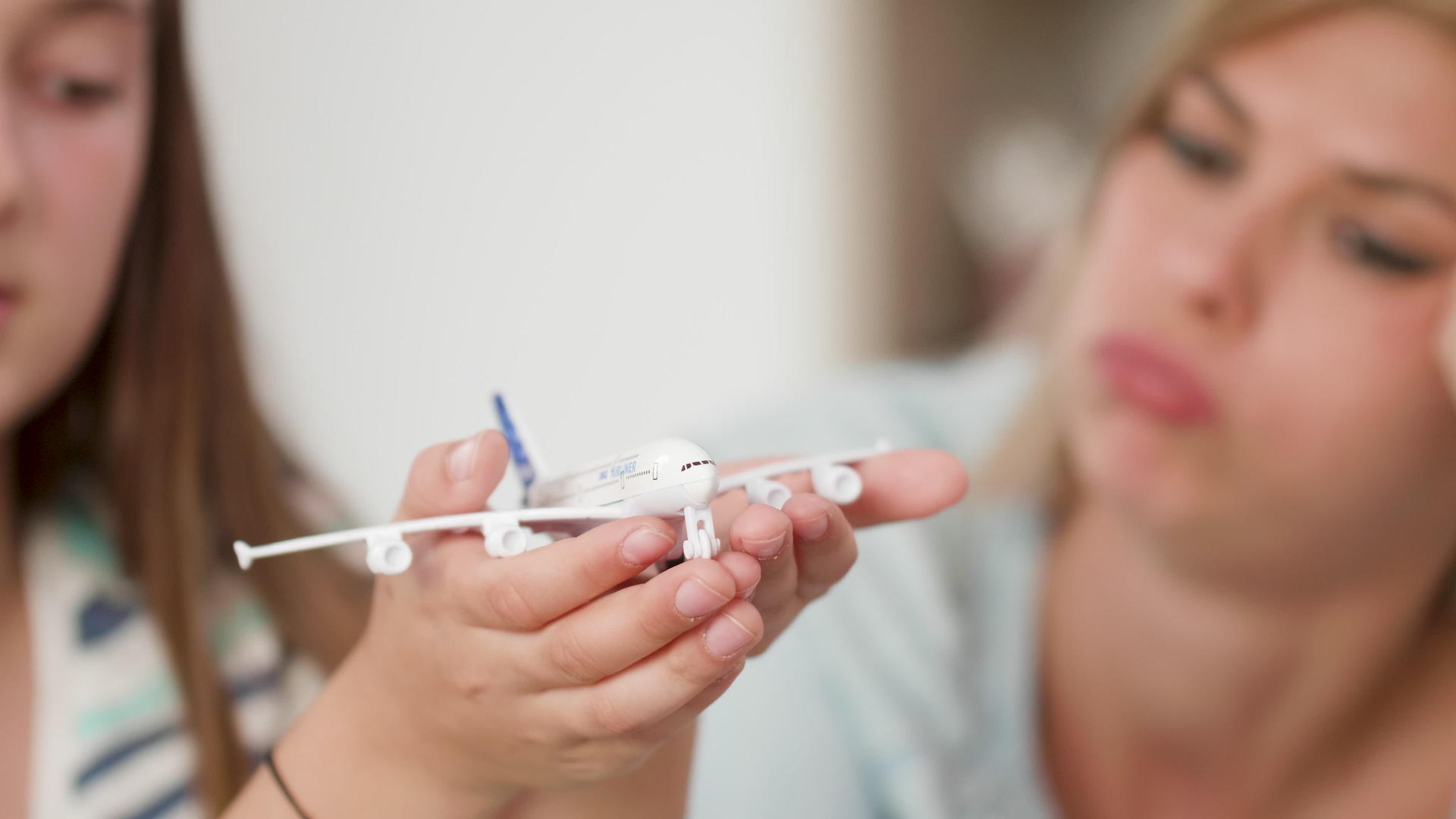 女孩手里拿着一架玩具飞机给妈妈看视频的预览图