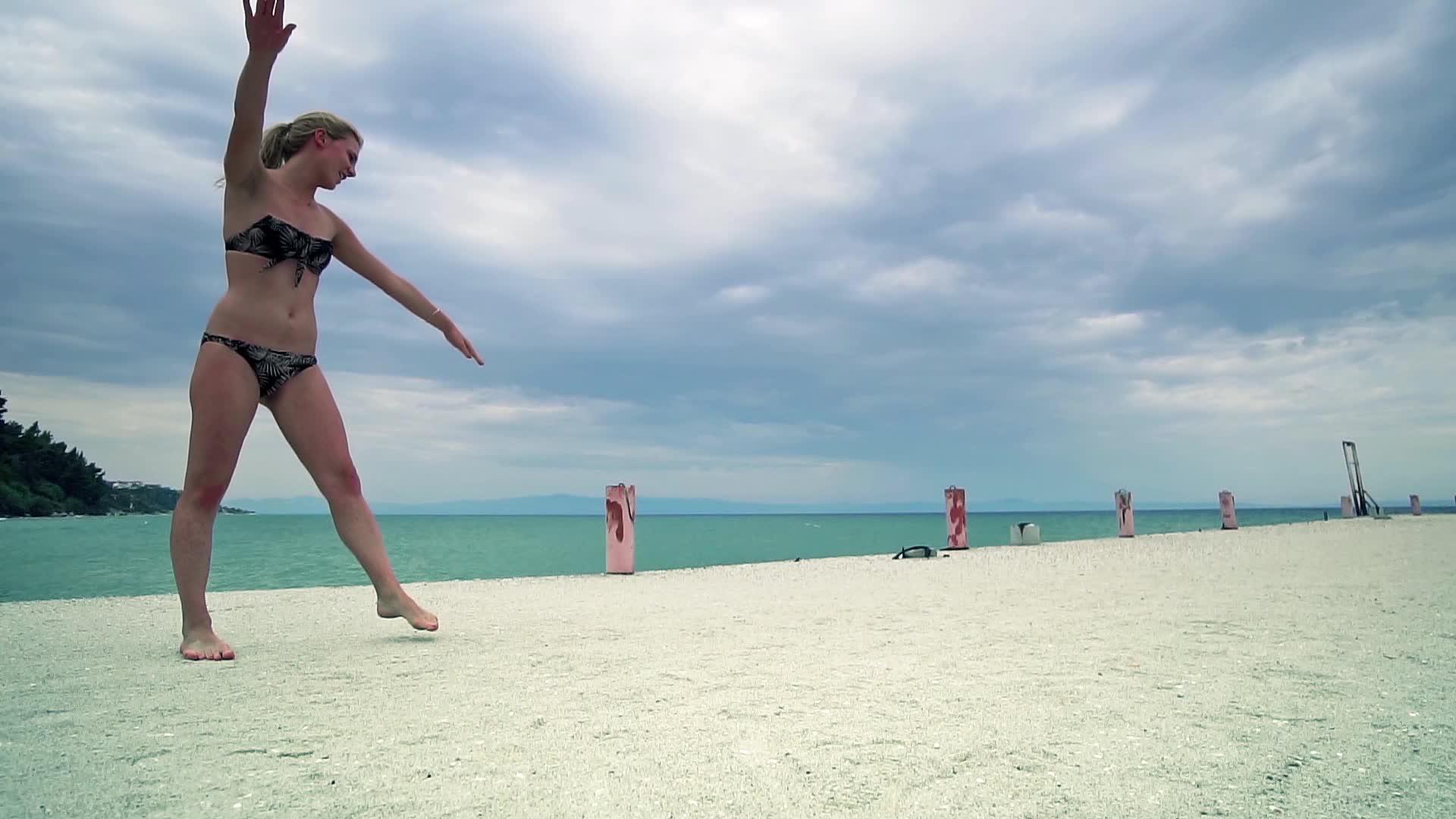 一个在海边码头玩体操的漂亮女孩视频的预览图
