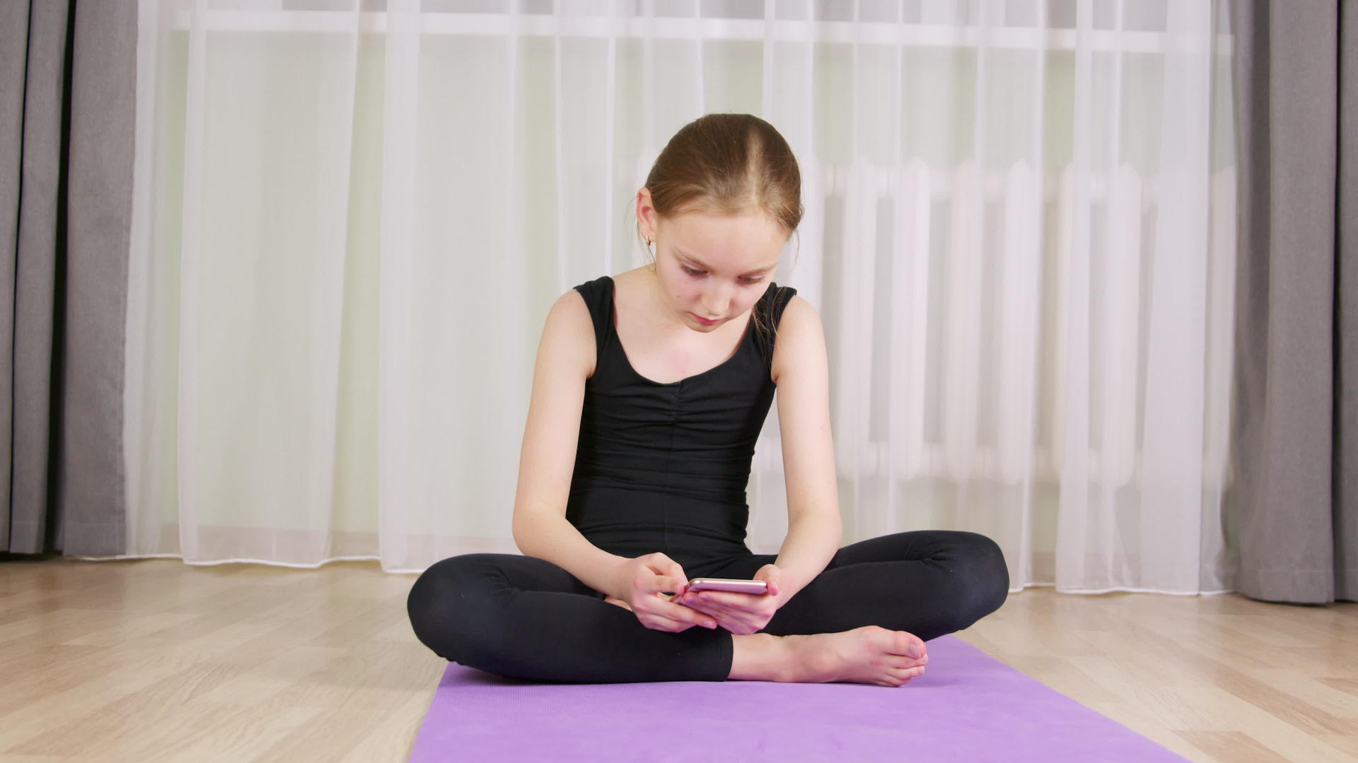 健身女孩在家里的瑜伽垫上用手机聊天视频的预览图