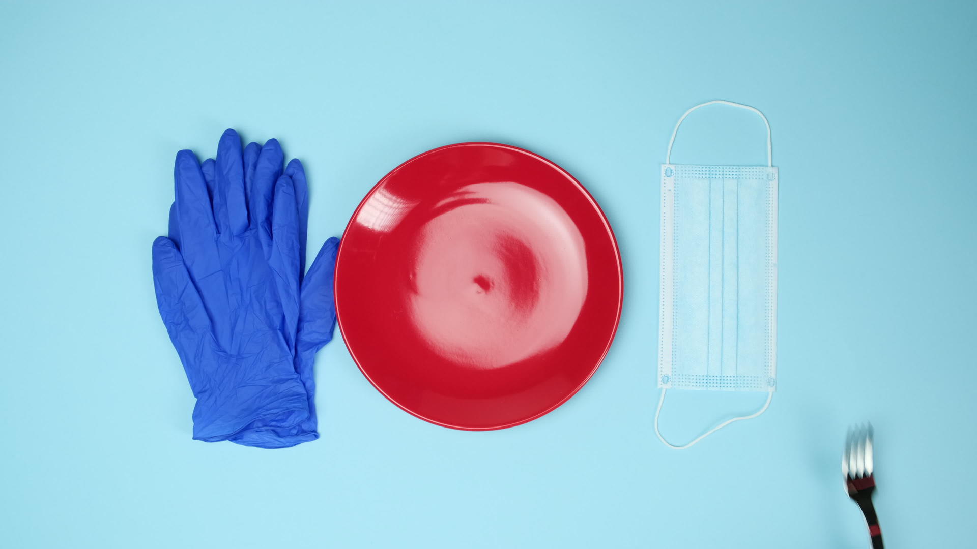 蓝色背景手套、红色陶瓷碗和口罩上的刀叉视频的预览图
