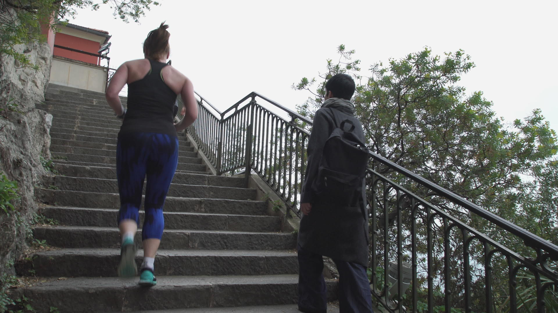 跑步者和背着包的女人走上楼梯视频的预览图